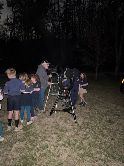 Scouts observing through telescope