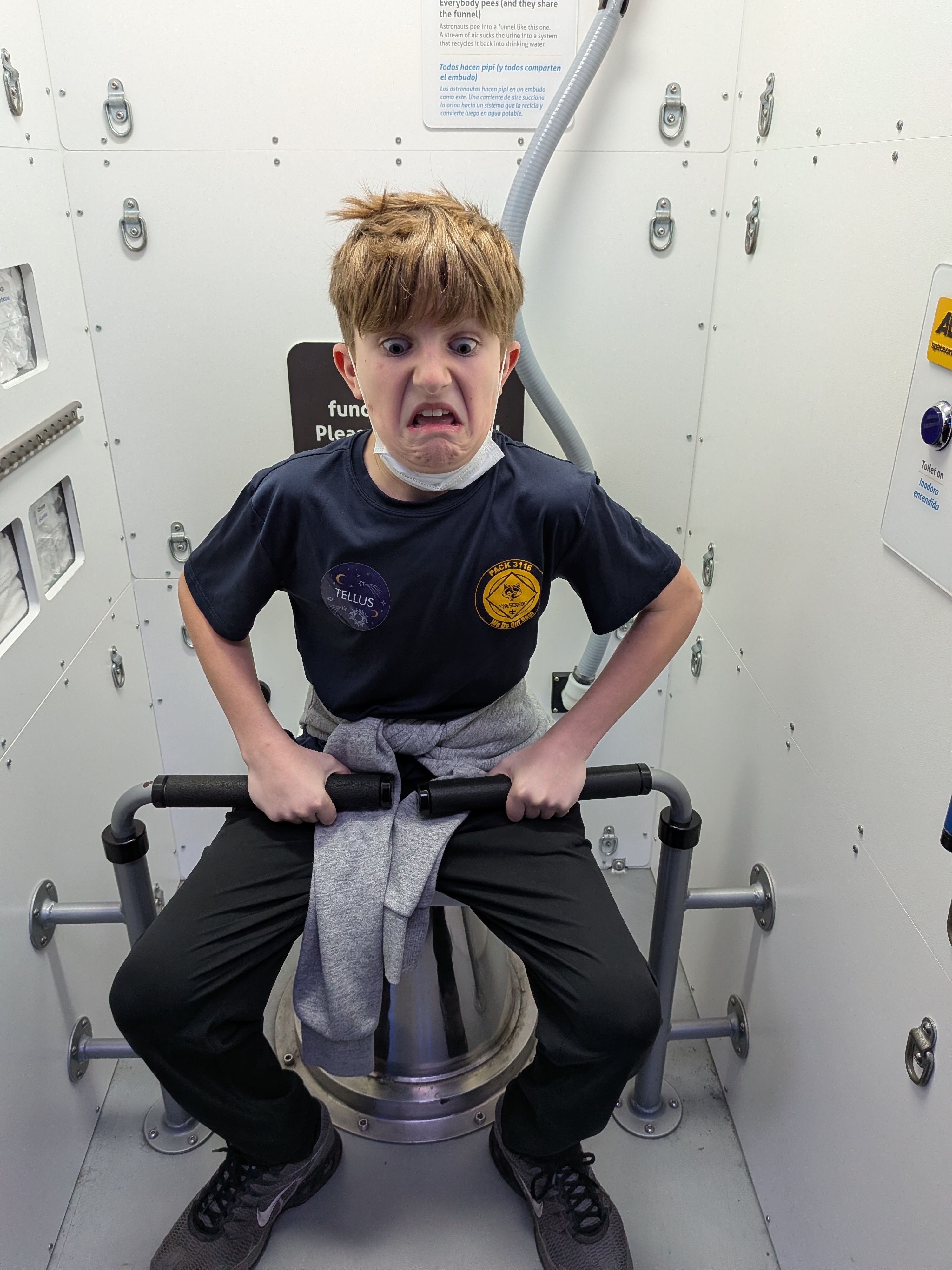 Scout exploring ISS toilet exhibit at Tellus